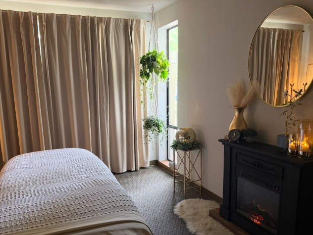 The treatment room with warm lamps, plants and the massage table